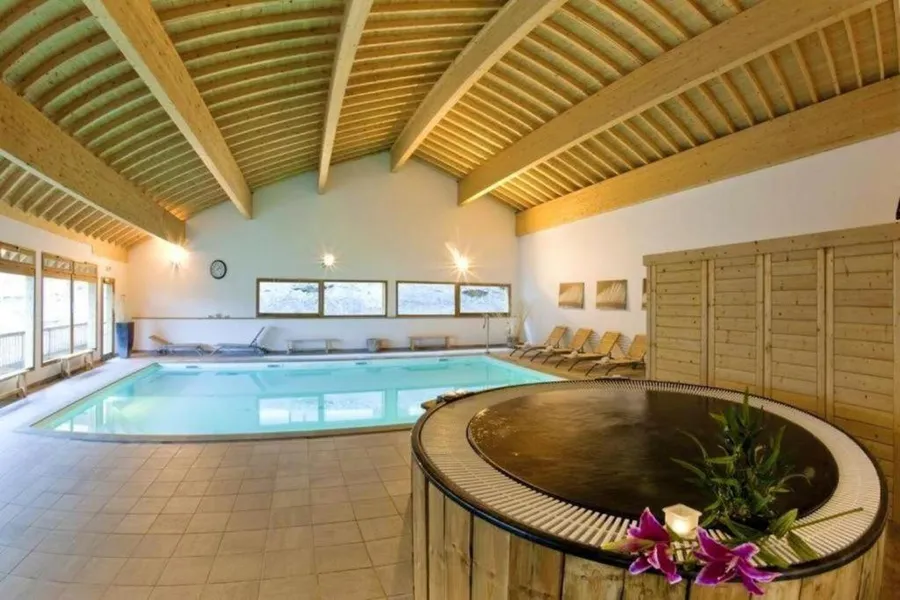 Piscine intérieure et jacuzzi de l'espace spa à Orelle